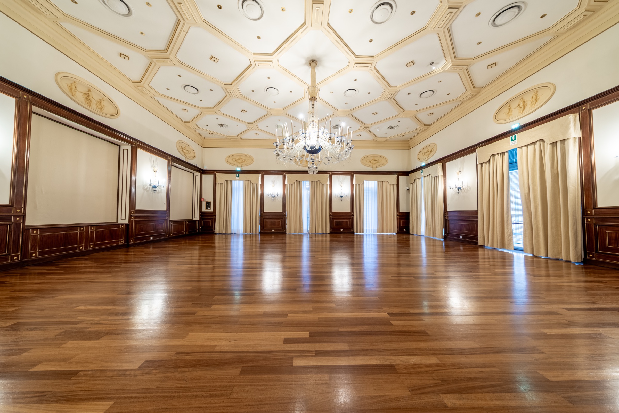 Salone del Casino di Sanremo con sedute in velluto e grande lampadario.